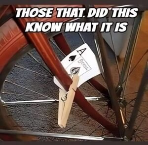 An ace of spades card attached to a bicycle wheel with a clothespin